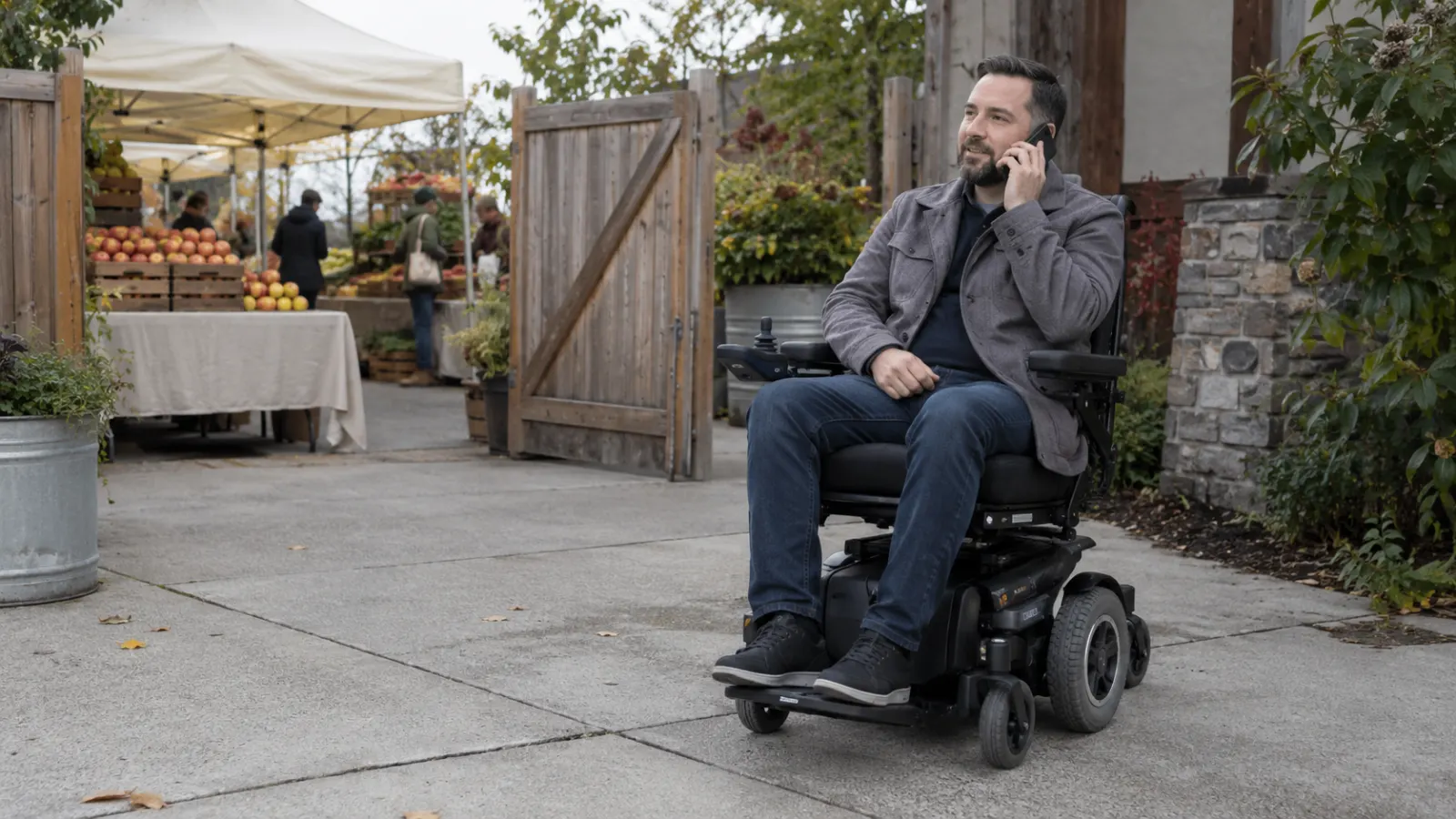 A power wheelchair user makes a phone call near a market entrance.