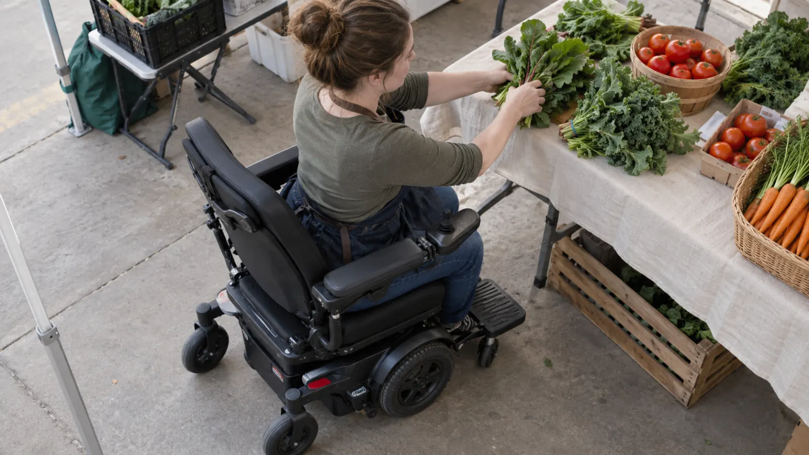 A power wheelchair user arranges vegetables on a market table.